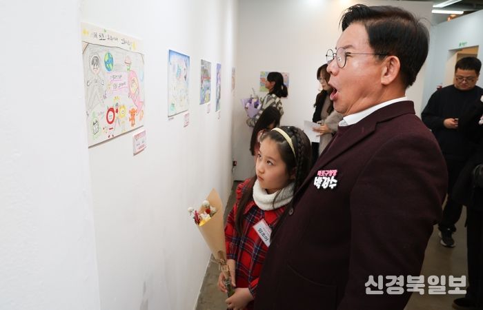 박강수 마포구청장이 수상 어린이와 함께 전시된 그림을 살펴보고 있다.